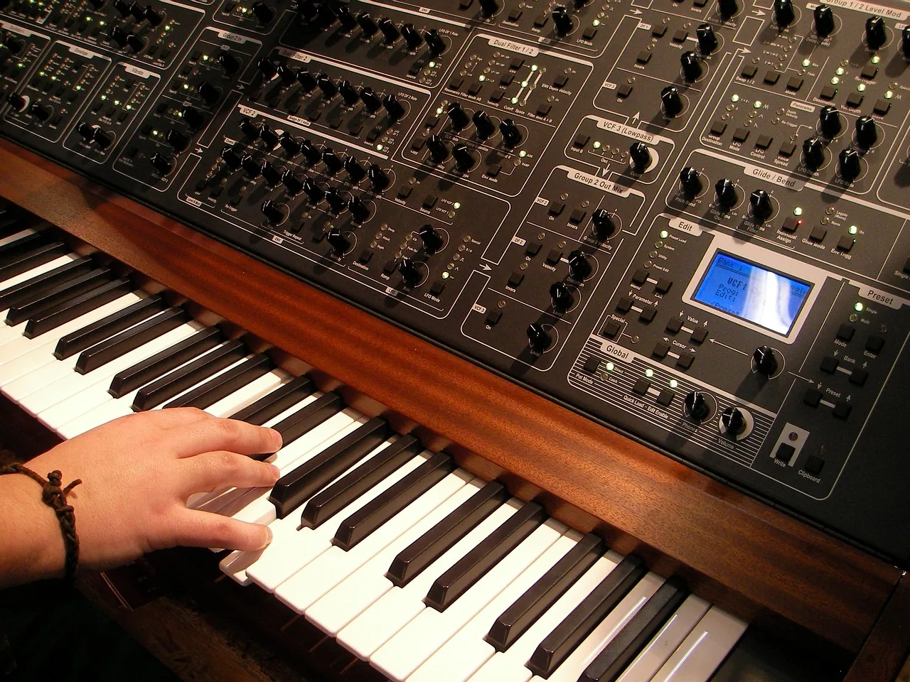 Musician playing an analog synthesizer Musician playing an analog synthesizer