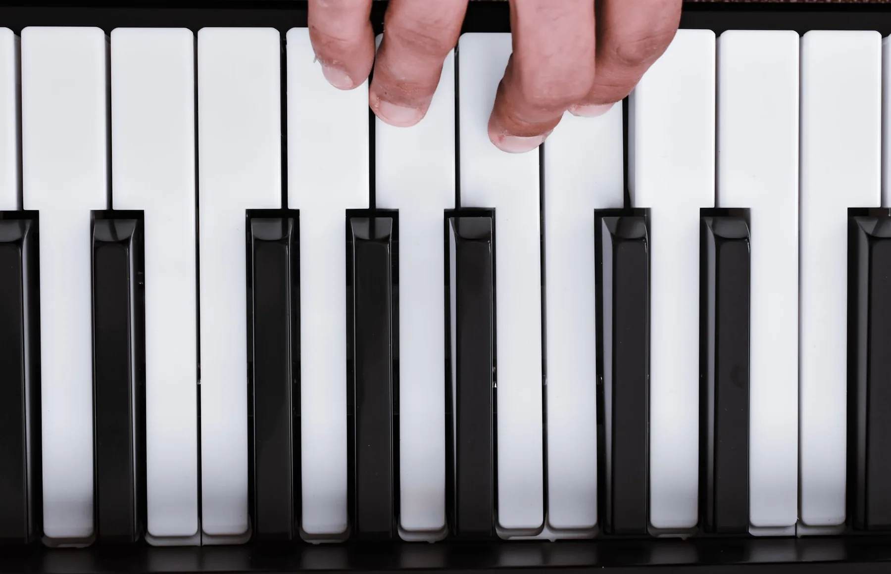 Hand playing an electronic keyboard