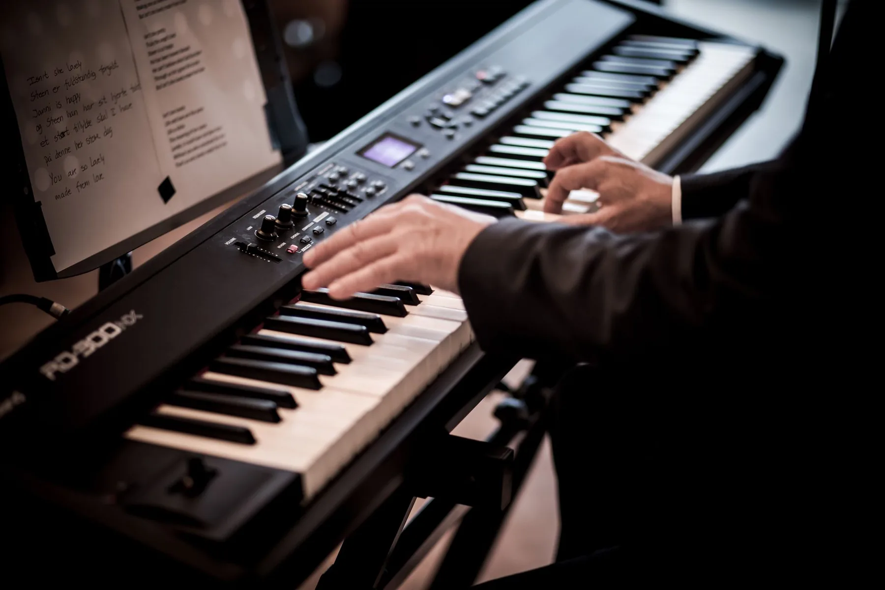 Musician playing a synthesizer Musician playing a synthesizer