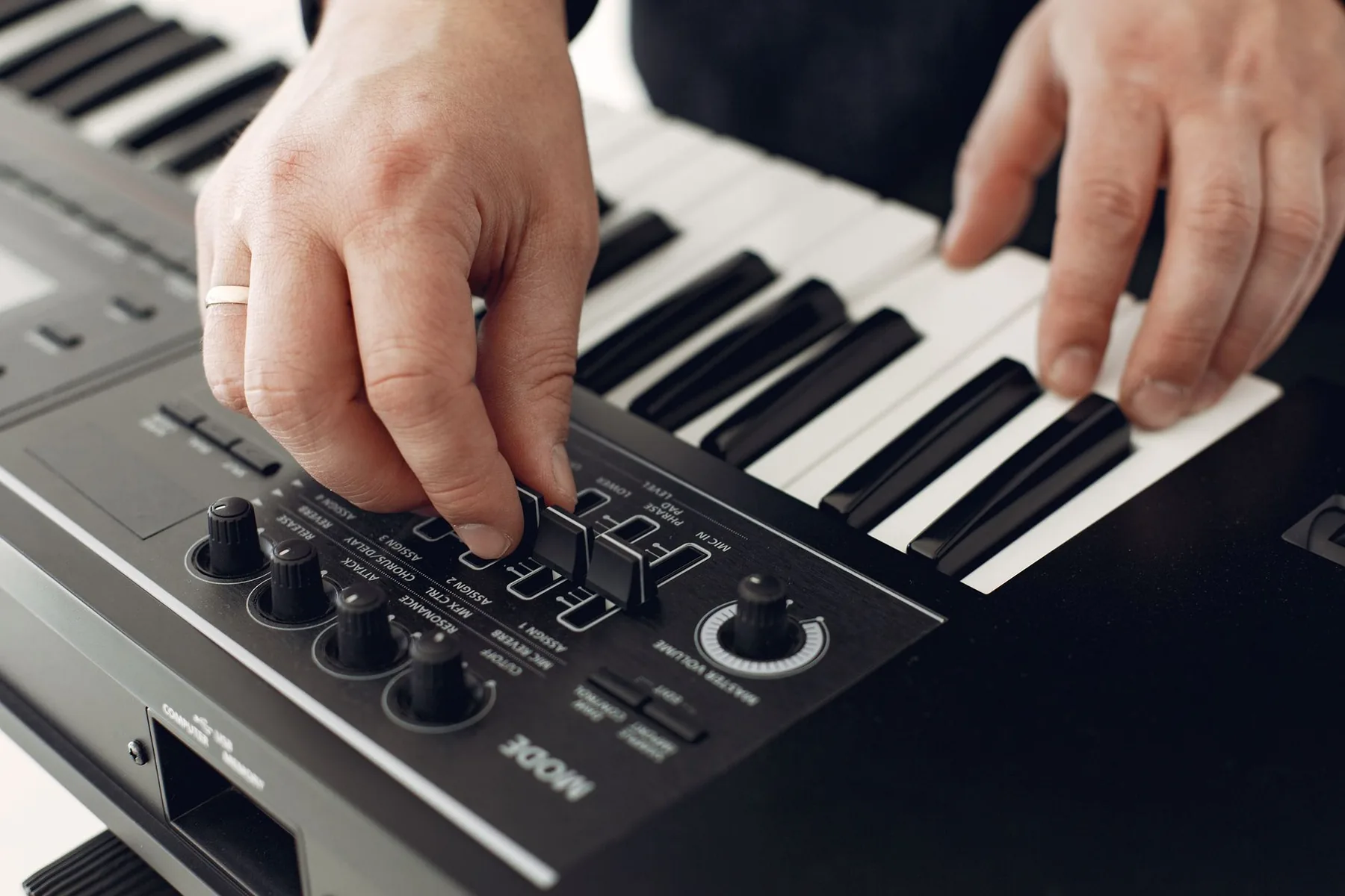 Musician adjusting a synthesizer keyboard Musician adjusting a synthesizer keyboard